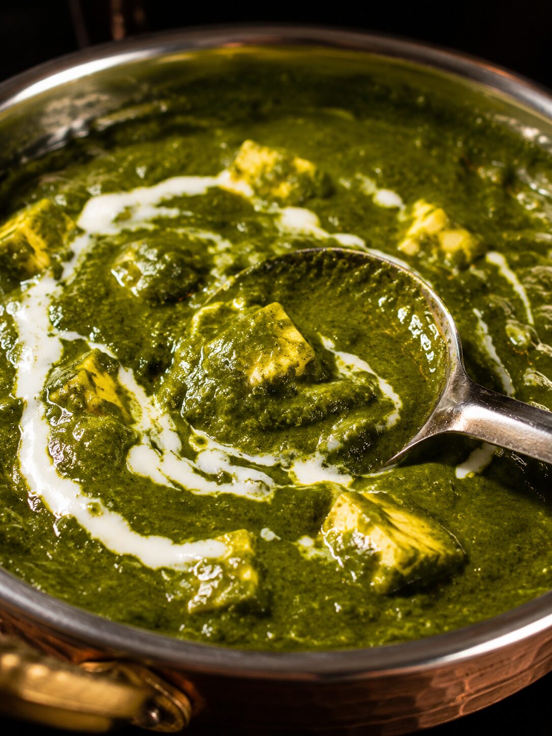 Authentisches Palak Paneer mit frischem Spinat und hausgemachtem Paneer im traditionellen Kupfergeschirr im Shiva's Garden Indian Restaurant in Villingen.